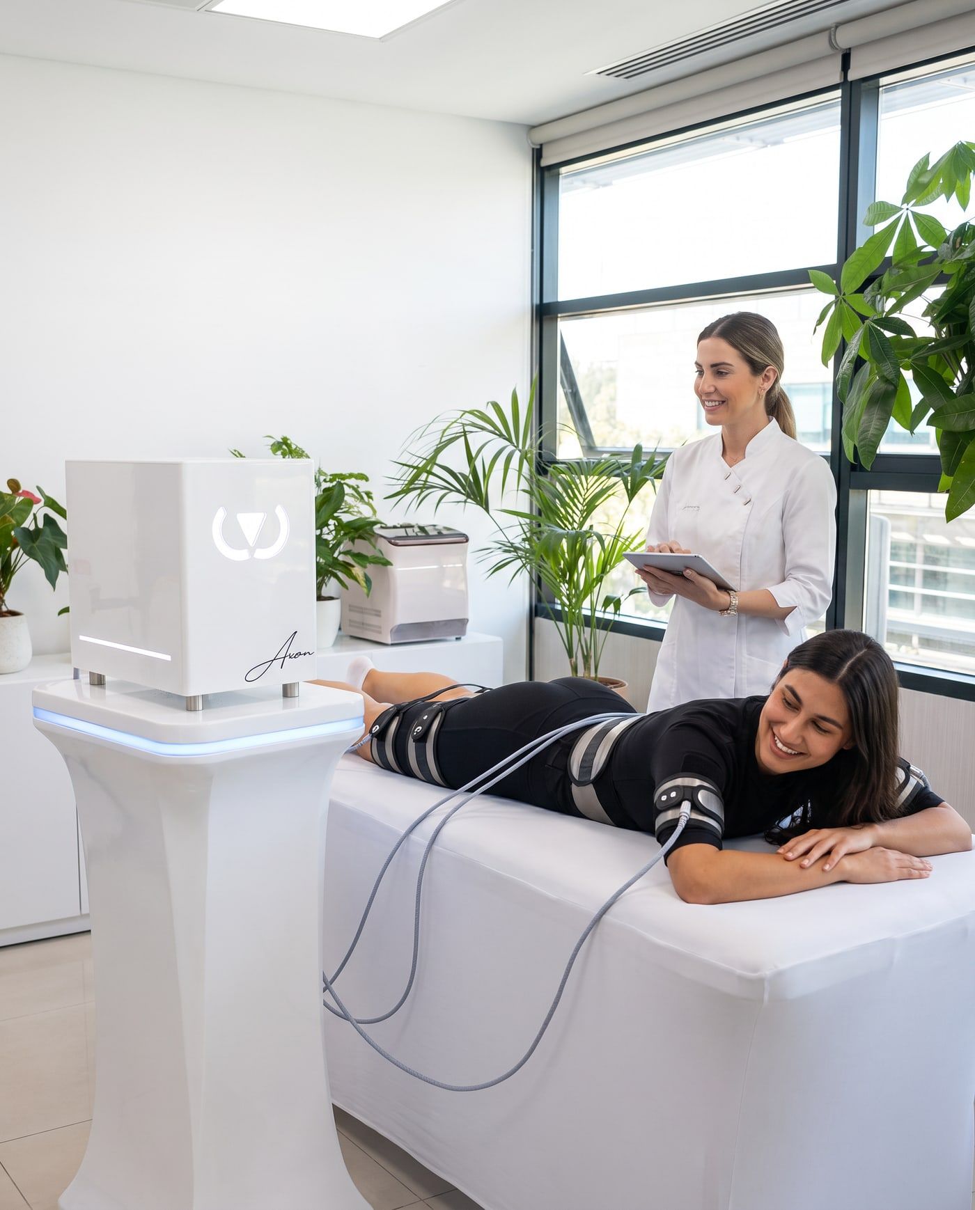 Client lying down with the Wonder Axon device and a specialist holding a tablet